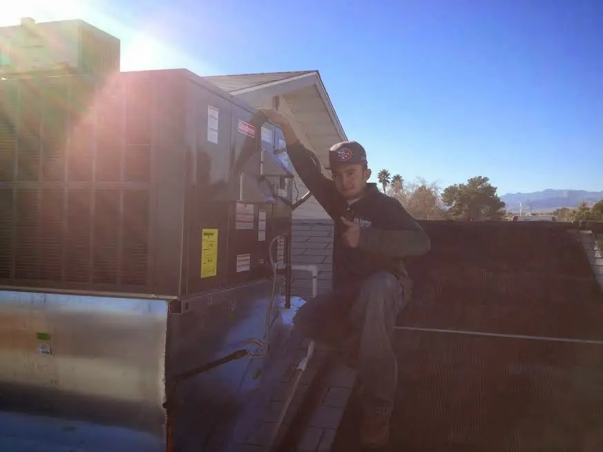 HVAC technician performing AC Tune-Up on a rooftop unit in Wauwatosa