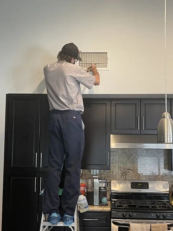 Technician inspecting an air vent during HVAC service in Wauwatosa